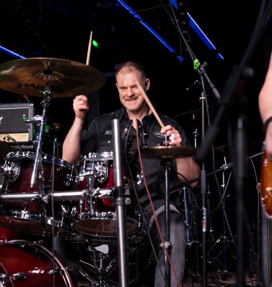 Mert kell egy csapat… és kell, hogy legyen benne egy elszánt, precíz dobos. Aki nemcsak a húzós alapokért felel, de mellette szemtelenül jóképű is. Aki a dollármilliókat hozó férfi modell és szépségipari karrierjét dobta sutba, amikor meghallotta a Rocksystem tagjainak hívó szavát, és 2023 óta tagja a vad bandának. Ő Erdélyi Szabi, aki a Rocksystem előtt több zenekarban megfordult már, de velünk végre megtalálta azt a zenei vonalat és zenésztársakat, akikkel igazán jól érzi magát.